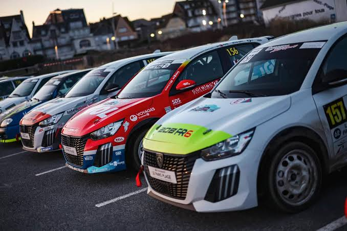 Alignement de Peugeot 208 FRC6 dans le parc d'assistance au coucher du soleil
