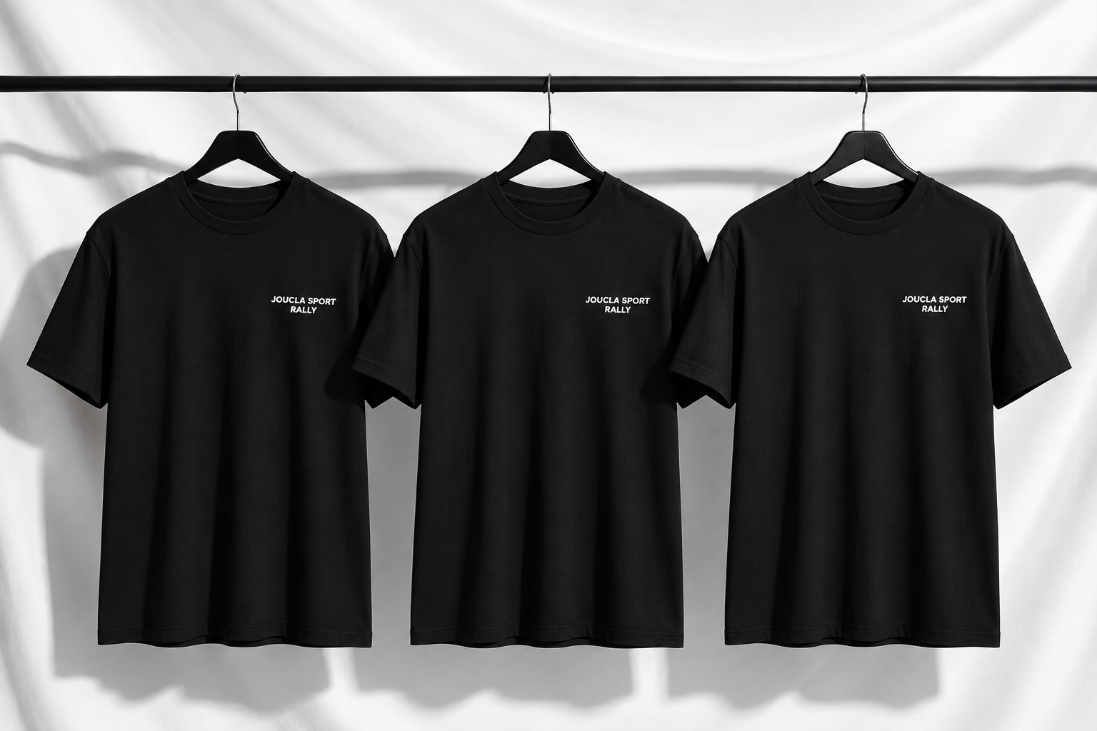 Tee-shirts noirs Joucla Sport Rally suspendus sur une barre